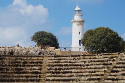 Lighthouse by sea against sky