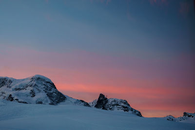 Scenic view of snow covered mountains against sky during sunset