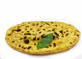 Close-up of bread in plate against white background
