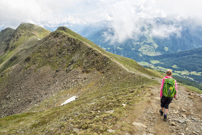 Man with umbrella standing on mountain