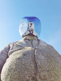 Low angle view of woman standing on rock