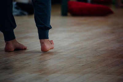 Low section of person standing on hardwood floor