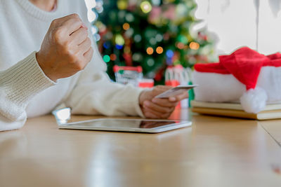 Midsection of man using smart phone on table