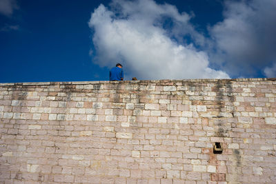 Low angle view of stone wall against sky