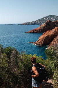 Rear view of woman looking at sea against clear sky