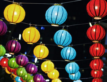 Low angle view of illuminated lanterns hanging at night