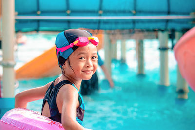 Cute girl standing in swimming pool