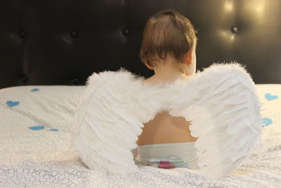 Close-up of cute baby with wings at home