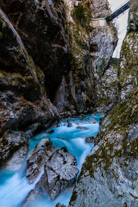 High angle view of river flowing amidst rocks