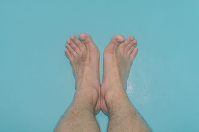 Low section of woman against blue background