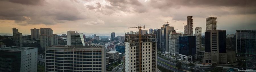Cityscape against cloudy sky