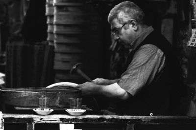 Side view of man preparing food