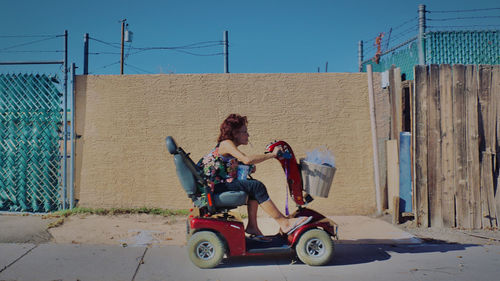 People sitting on motorcycle against sky