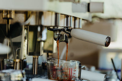 Espresso shot coffee flows from the coffee machine.