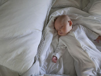 High angle view of baby boy sleeping on bed at home