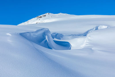 Snow covered mountain against blue sky