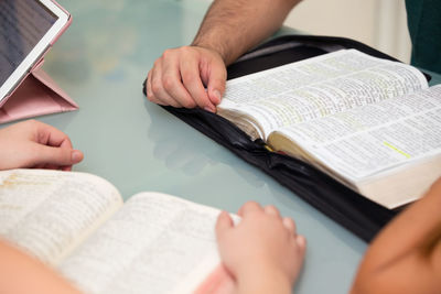 Cropped hands of people with books at table