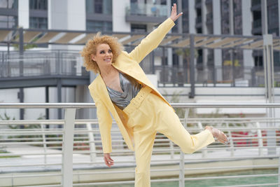 Urban style street fashion photosoot young girl with curly hair wearing yellow trendy suit 