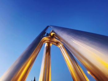 Low angle view of metallic structure against clear blue sky