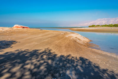 Scenic view of beach against blue sky