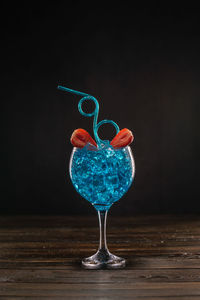 Close-up of wine glass on table against black background