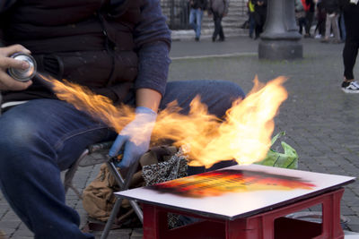 Midsection of man preparing food on barbecue grill