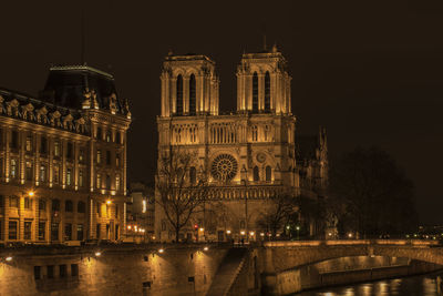 Illuminated buildings by river at night