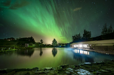 Secret lagoon in flúðir village in iceland with northern lights reflecting in the pool water