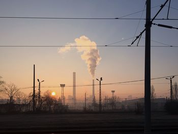 Smoke emitting from factory against sky