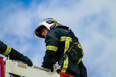 Low angle view of man wearing mask against sky