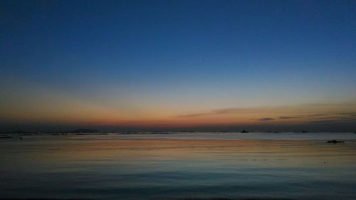 Scenic view of sea against clear sky at sunset