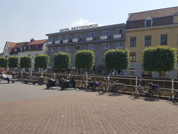 People on street against buildings in city