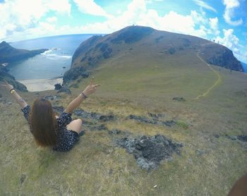 Rear view of woman walking on mountain against sky