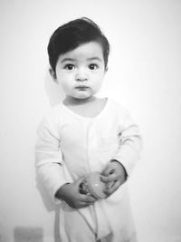 Portrait of cute boy standing against white background
