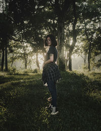 Portrait of young woman standing on field