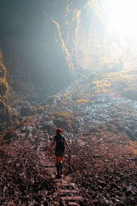 Rear view of man standing on mountain against sky