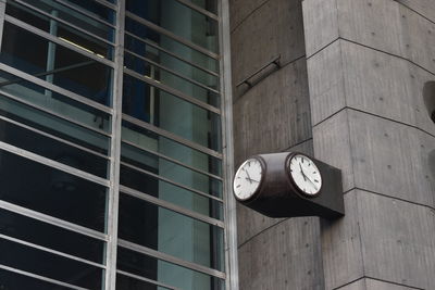 Low angle view of clock on wall in city