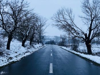 Road amidst bare trees during winter