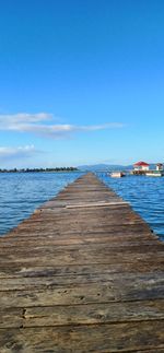 Pier over sea against blue sky