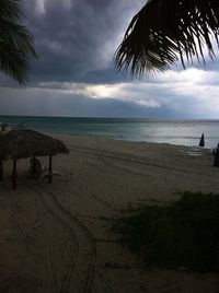 Scenic view of beach against cloudy sky