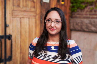 Portrait of young woman wearing eyeglasses outside language school