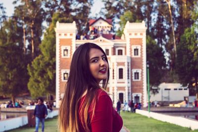 Portrait of smiling woman against building