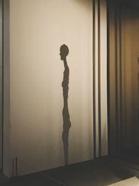 Side view of silhouette man standing against wall