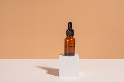 Close-up of bottle on table against yellow background