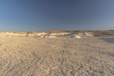 Scenic view of desert against clear blue sky