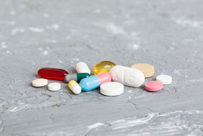 Close-up of pills spilling from bottle on table