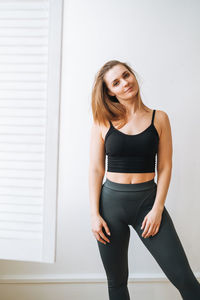 Young slim woman in sportwear dancer at bright studio