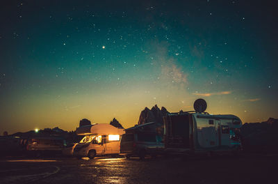 Cars on road against sky at night