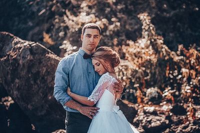 Couple kissing against trees