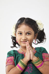 Smiling girl praying over white background